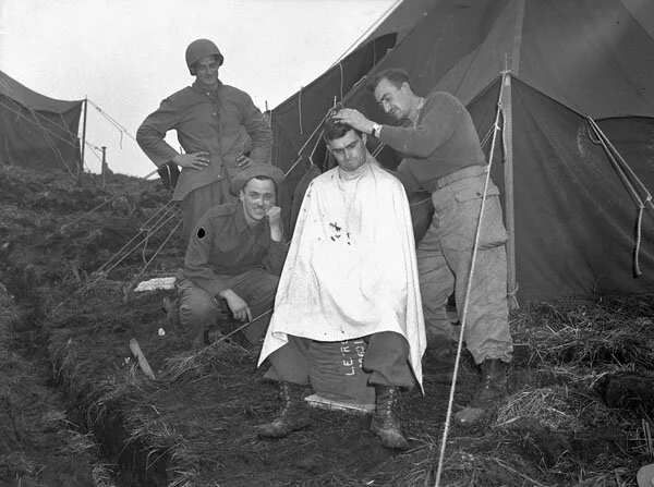 An unidentified infantryman of Le Régiment de Hull getting a haircut, Kiska, Aleutian Islands, August 1943 Item ID number:3230065
