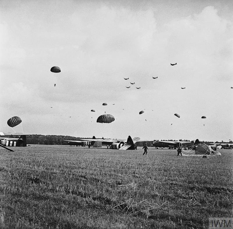 Paratroops landing at Wolfheze. Sections of gliders lie on the landing field.