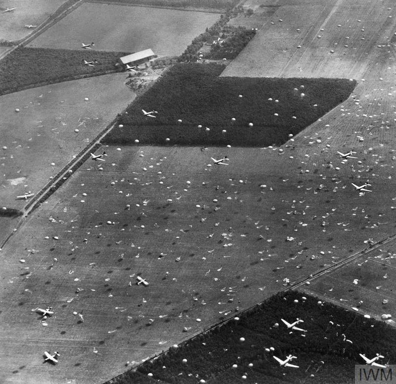Oblique photographic-reconnaissance aerial showing Douglas Dakotas dropping paratroops of 1st Airborne Brigade on to Dropping Zone (DZ) 'X', at Renkum, west of Arnhem. Some Horsa gliders have already landed.