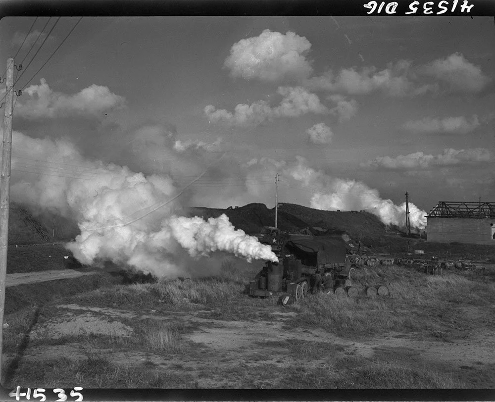 Smoke machines along dyke, alligator on return trip carrying wounded prisoners and evacuees, Scheldt pocket embarkation point, West of Terneuzen