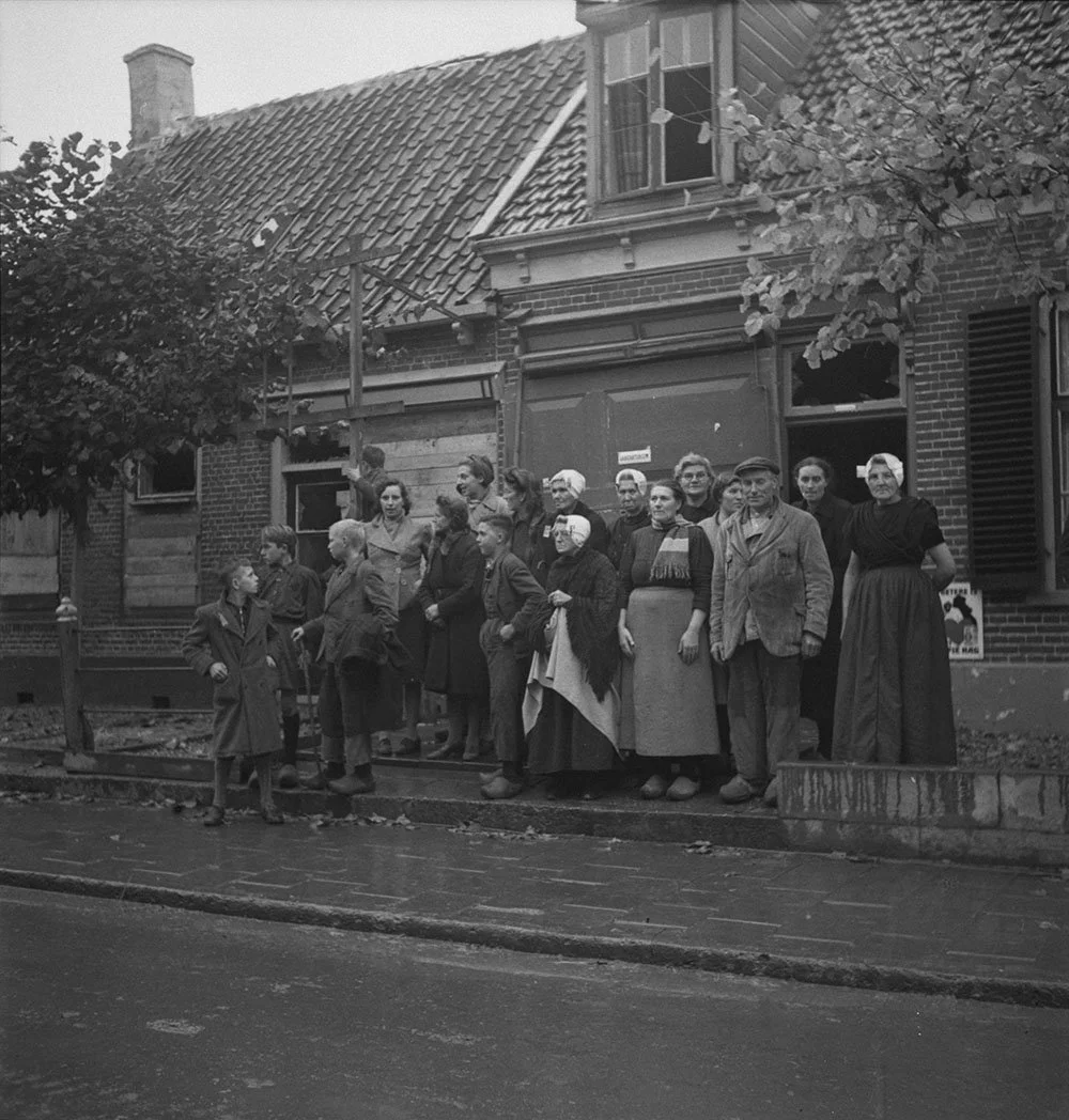 Group of villagers watching troops of the 2 Canadian Infantry Division during the occupation of the Beveland Causeway. Krabbendijke, Netherlands, 27 Oct. 1944
