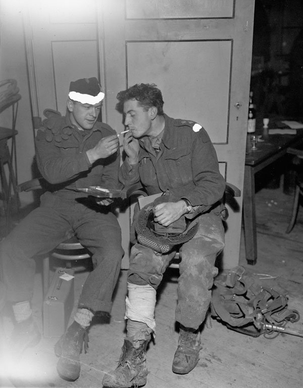 Private D. Tillick of the Toronto Scottish Regiment (M.G.) and Lieutenant T.L. Hoy of the Calgary Highlanders, who both were wounded on the causeway between Beveland and Walcheren, waiting for treatment at the Casualty Clearing Post of the 18th Fiel