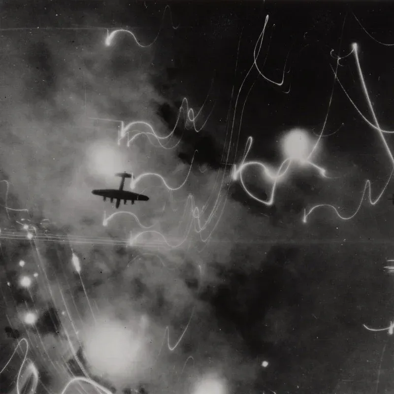 Lancaster silhouetted against flares, smoke and explosions during the attack on Hamburg, 30/31 January 1943