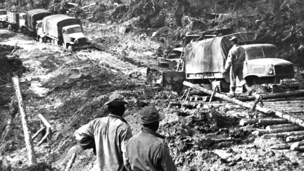 Trucks driving through mud along the Alaska Highway as it is being built