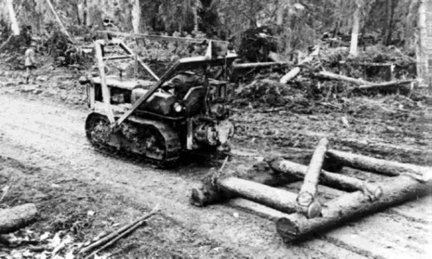 D-4 dozer pulls a makeshift grader crafted from local timber on the Alaska Highway