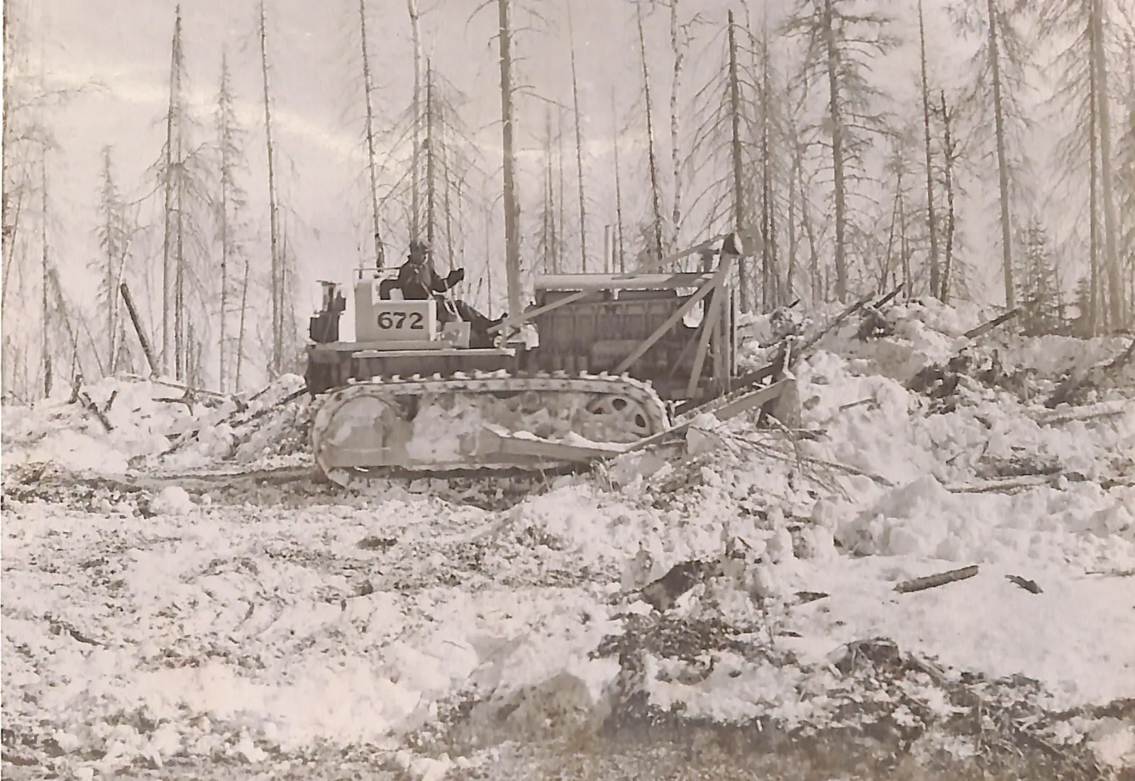 A caterpillar tractor with dozer widens the roadway of the Alaska Highway