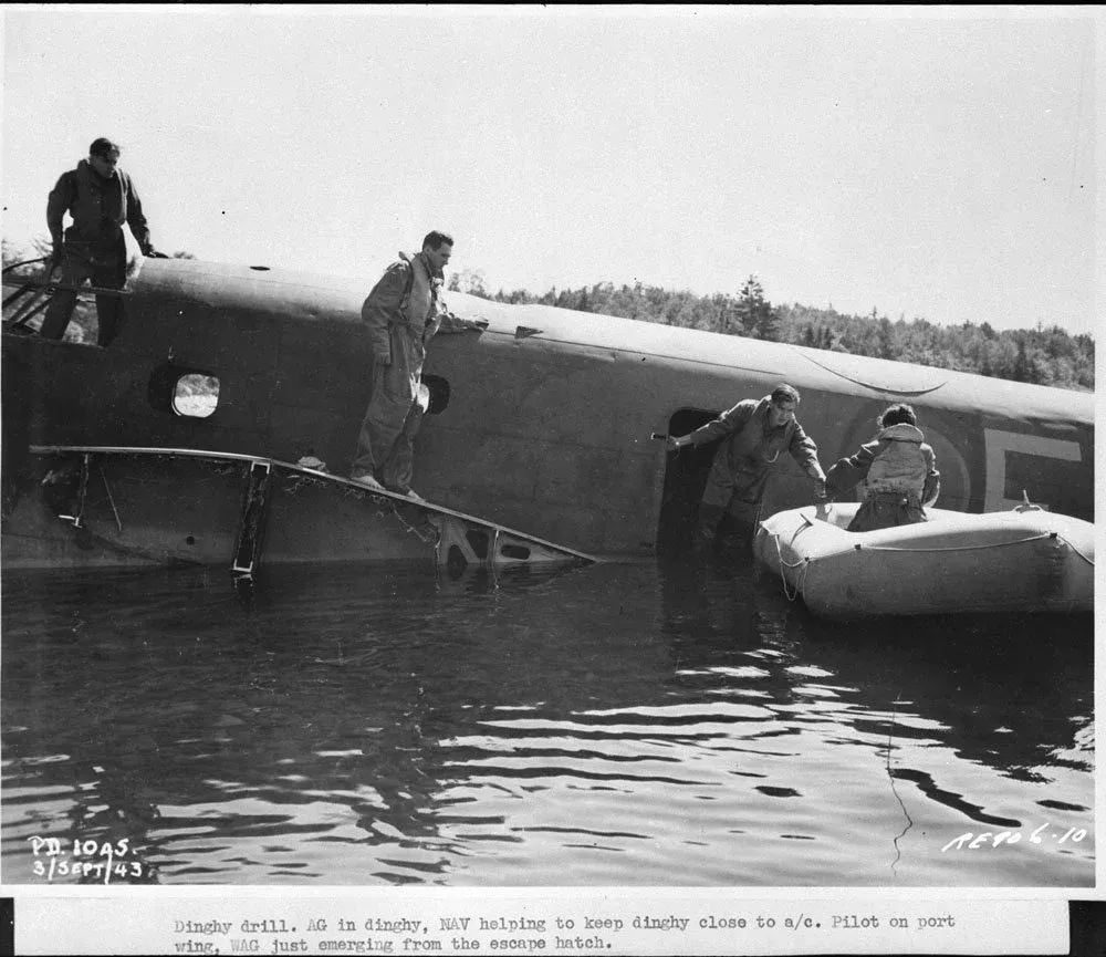 Personnel demonstrating the use of a dinghy during the simulated crash landing of a Lockheed Ventura aircraft in the Ottawa River, RCAF Station Rockcliffe, 29 November 1943