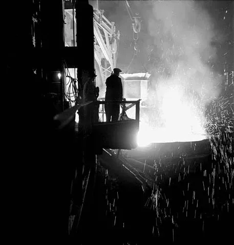 Workman observes an open hearth furnace being tapped out at the Stelco Steel Company of Canada plant
