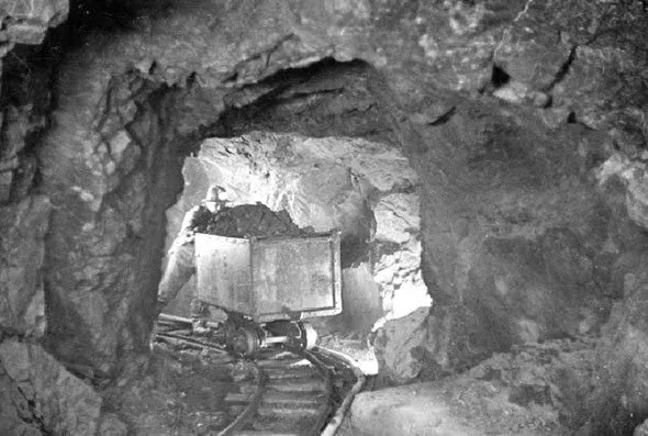 A miner hauling a car of uranium-bearing ore at Eldorado Mine, Great Bear Lake, NWT