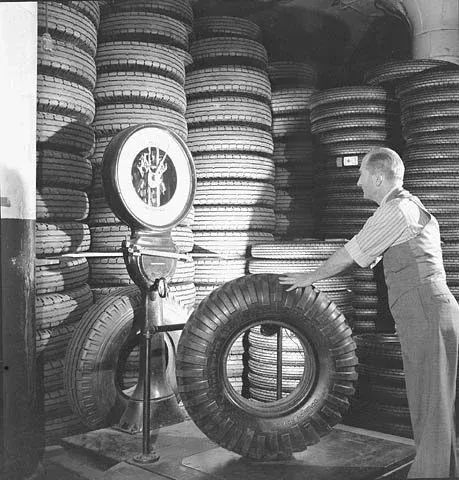 Tires being weighed by workman T.G. Hillman in the Polymer Rubber Corporation plant